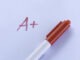 A+ Grade on Exam Paper with Red Pen on White Background