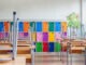 Modern emty classroom with colorful lockers and raised chairs on the tables