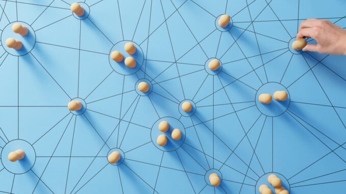 Social media networking. Network with members connected with each other. Group of people. Communication, teamwork, community, society. Abstract concept with wooden pieces on blue background.